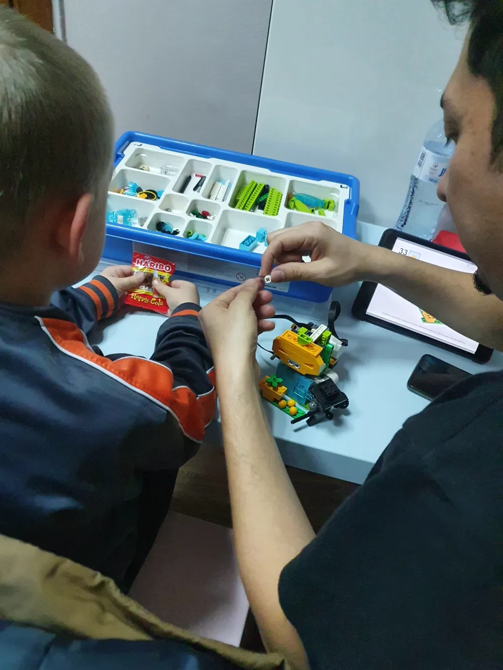 Dzieci budują robota z klocków LEGO razem z lektorem na zajęciach w Eurolink Leszno